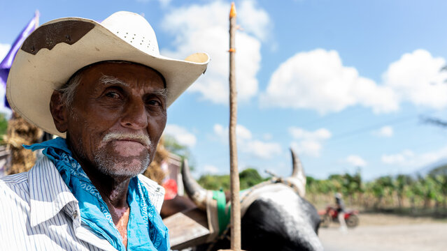 Closeup to the face of a Latino farmer with vitiligo who carries a rod to steer oxcarts