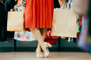 Fototapeta na wymiar Shopping Woman Walking in a Store Wearing Elegant Sandals .Elegant fashionista carrying her shopping bags in fashion boutique 