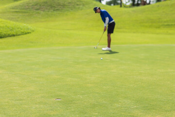 Obraz premium Golfers putting golf balls on the green amid the warm sunshine in the morning. Concept of Outdoor activities and Outdoor sports, Concept of Golfer and Lifestyle.