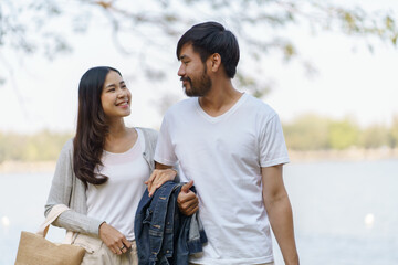 Portrait of lovely happy Asian couple Man and woman relaxing together at the park.