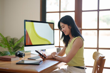 Obraz premium Asian creative woman sitting and working on computer creating an artwork..