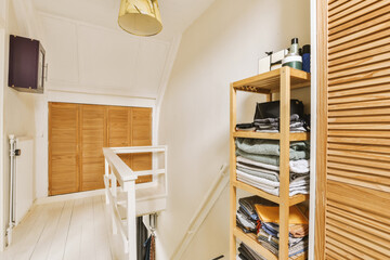 a room with wooden shutters on the wall and white wood flooring in front of the door, there is an open closet