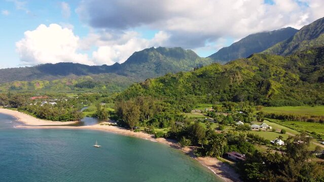 Breathtaking Aerial panoramic shot of Hanalei Valley and green mountains, beach, boat, ocean with the Hanalei River  near Princeville, Kauai, Hawaii