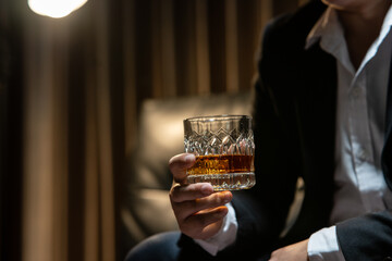 Businessman sitting Holding a Glass of Whiskey Drink Whiskey in the liquor store room