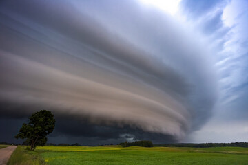 Naklejka na ściany i meble Angry supercell storm influenced by Climate change. Dangerous storm supercell shelf cloud with layers.