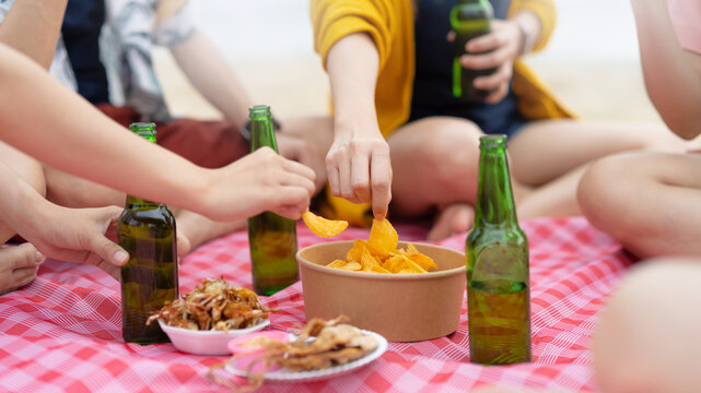 Group Of Happy Young People With Chips Sharing With Friends In  Party At Beach