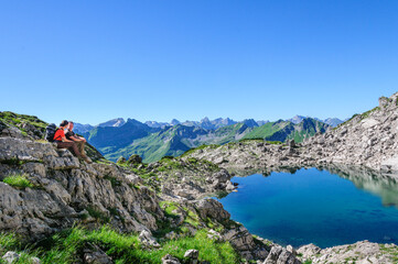 Zwei Wanderer genießen den herrlichen Ausblick in die alpine Bergwelt des Allgäus