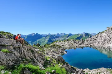 Poster Zwei Wanderer genießen den herrlichen Ausblick in die alpine Bergwelt des Allgäus © ARochau
