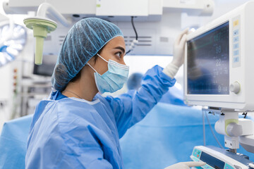 Anesthesiologist keeping track of vital functions of the body during cardiac surgery. Surgeon...