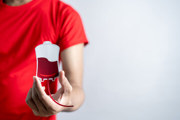 Hands holding blood drop paper cut, blood transfusion, world blood donor day, red cross to give...