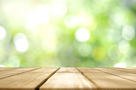 Empty wooden table with Blurred image of abstract circular green bokeh from nature style background.