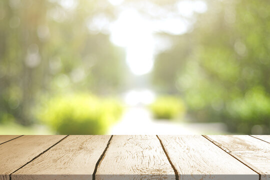 Empty wooden table with Blurred image of abstract circular green bokeh from nature style background.