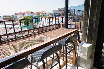 View from the terrace of a modern flat with table and chair at rooftop restaurant.