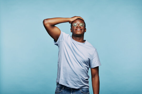 African man standing with a hand on his head