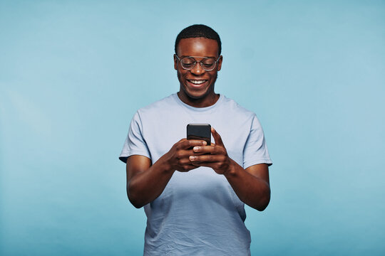 Laughing African man texting on his phone