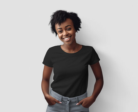 Black t-shirt mockup on smiling african american woman with curly hair, hands in jeans pockets, isolated on background, front view.