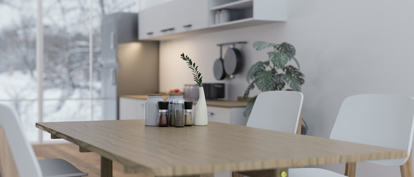Close-up image of a minimal wooden dining table in a modern contemporary white kitchen.