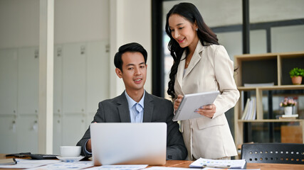 A gorgeous Asian businesswoman is briefing a male employee, discussing work