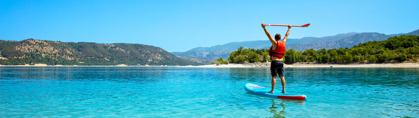 SUP Stand up man with paddle on lake in France (Verdon)