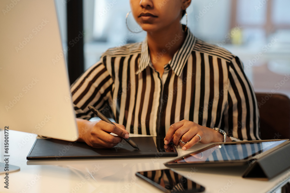 Aufkleber Hands of young female graphic designer with stylus and touchpad sitting by desk in front of computer monitor and creating new sketches