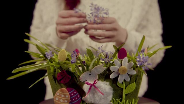Ein Osterkorb wird mit Blumen geschm&uuml;ckt