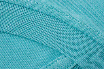 Fragment of a turquoise t-shirt shot close-up.