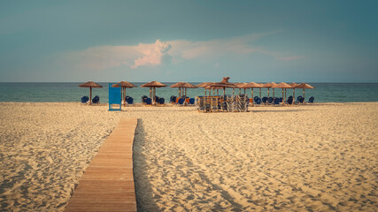 early evening beach with sunbeads and parasols - 615008575