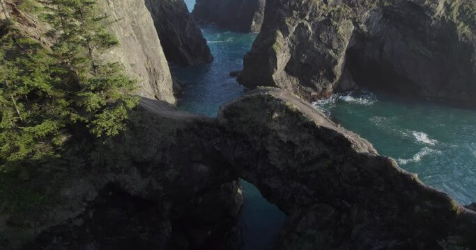 Natural Bridges Arch on Rocky Oregon Coastline - Aerial Tilt-up