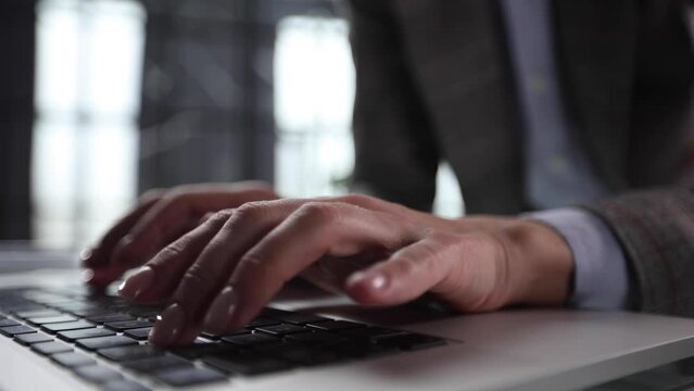 Hands of a man typing fast on a computer keyboard