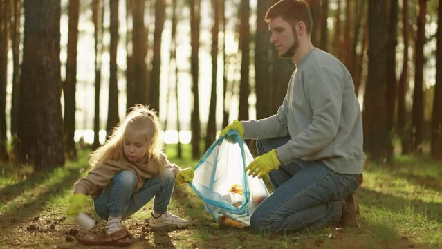 Little Girl And Her Father Cleaning Forest From Plastic Garbage, High Five Gesture, Ecology Save