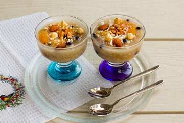 Traditional Turkish Dessert Asure,Noah's Pudding in stylish glass bowls on wooden table