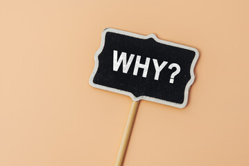 Why - word on a small chalkboard on a beige background. Top view. Business answer and analysis, problem ask, interrogation, research information concept