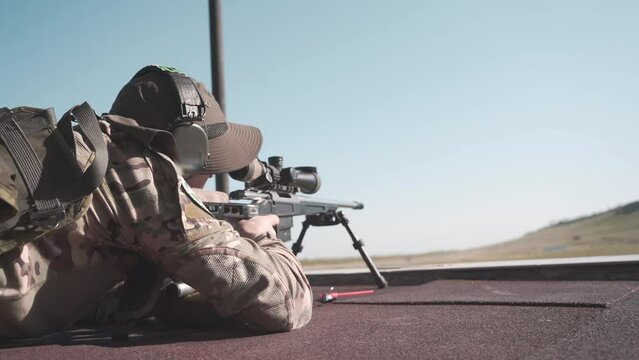 the shooter adjusts the sight, loads the rifle and makes a shot