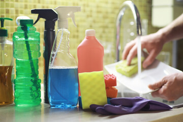 A bottle with an environmentally friendly dishwashing detergent on the background of a housewife...