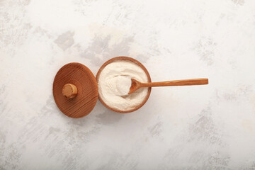 Xanthan Gum Powder in wooden bowl with spoon, top view. Food additive E415. Texture improver....
