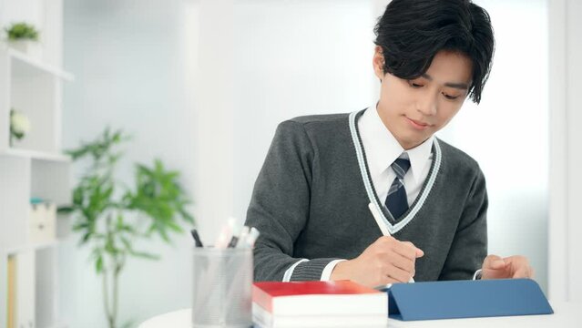 タブレットで勉強する男子学生
