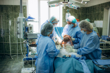 Baby being born via Caesarean Section coming out. Newborn child seconds and minutes after birth....