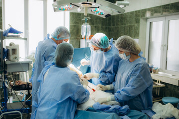 Surgical team performing surgery operation. Doctor performing surgery using sterilized equipment....