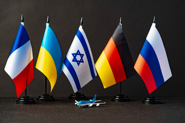 Flags and toy airplane close up. Travel concept