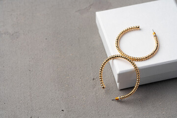 Golden earrings and jewelry box on table close up