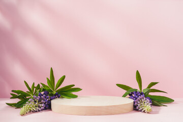 Wooden round podium pedestal. Сosmetic beauty product presentation  on  pink background with flowers