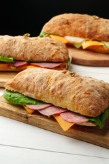 Chiabatta sandwich with ham and cheese on wooden board