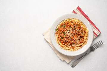 Spaghetti bolognese pasta in ceramic plate on light gray background. Italian traditional cuisine