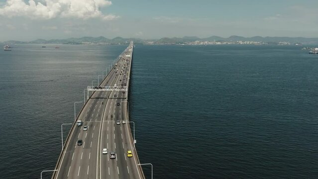 Aerial circular view highway Bridge over the ocean lead to city of Rio de Janeiro, Brazil. Modern architecture bridges and traffic, transportation, tolls concept