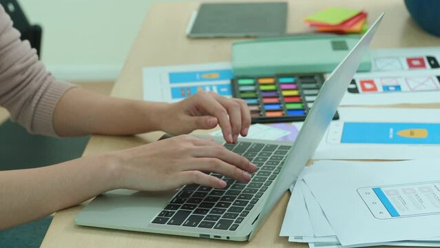 Group of asian creative team programing using computer while designers participate in all phases of the UX UI design.
