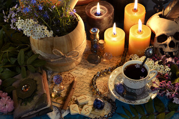 Mortar with healing herbs, runes and candles on altar table. Occult, esoteric and fortune telling still life. Mystic background with vintage objects