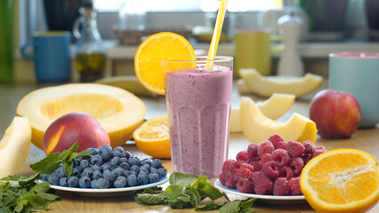 Raspberry Blueberry Melon Smoothie into a glass on the background of fresh fruits