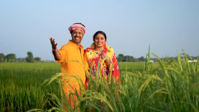 In the vibrant spring of Great India, a harmonious Indian farmer and his wife stand united in the field, embracing nature's abundance with joy, pride, and their diligent spirits.