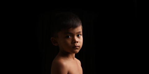 portrait of  asian boy on a black background.