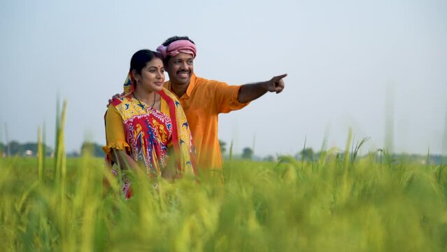 In the bountiful fields, an Indian farmer and his wife stand together, radiating joy and pride, content with a plentiful harvest, embodying the spirit of hardworking and proud farmers.